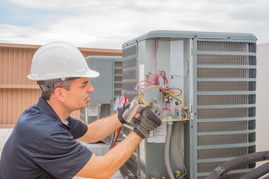 BHMS technician performing emergency repair on an outdoor AC unit